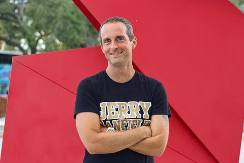 Jerry Banfield standing in front of a red sculpture
